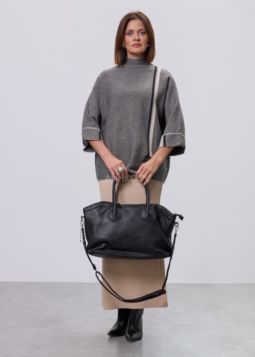 Damska, luźna bluzka o kroju oversize w kolorze szarym, z półgolfem i rękawami 3/4, ozdobiona pionowym kontrastowym paskiem, prezentowana na modelce na jasnym tle