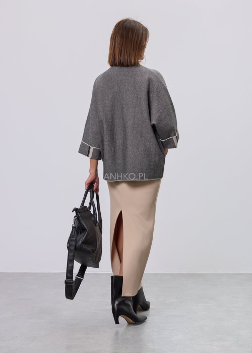 Damska, luźna bluzka o kroju oversize w kolorze szarym, z półgolfem i rękawami 3/4, ozdobiona pionowym kontrastowym paskiem, prezentowana na modelce na jasnym tle