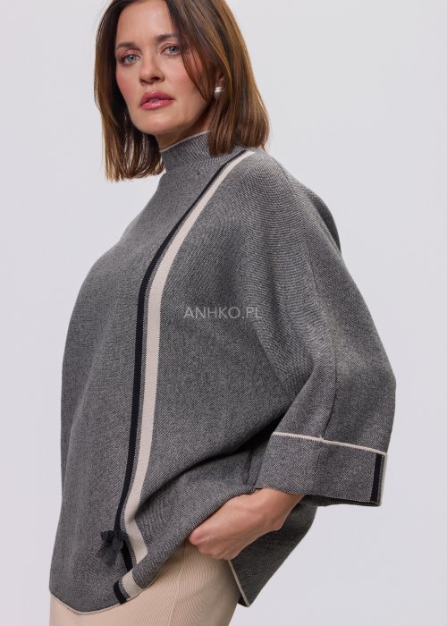 Damska, luźna bluzka o kroju oversize w kolorze szarym, z półgolfem i rękawami 3/4, ozdobiona pionowym kontrastowym paskiem, prezentowana na modelce na jasnym tle