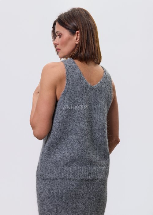 Trzyczęściowy komplet w odcieniu szarości: dzianinowa sukienka midi bez rękawów, długi luźny kardigan oraz dopasowany top, całość uzupełniona masywnym srebrnym naszyjnikiem i czarnymi botkami.