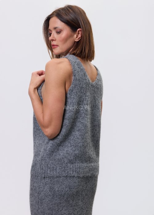Trzyczęściowy komplet w odcieniu szarości: dzianinowa sukienka midi bez rękawów, długi luźny kardigan oraz dopasowany top, całość uzupełniona masywnym srebrnym naszyjnikiem i czarnymi botkami.