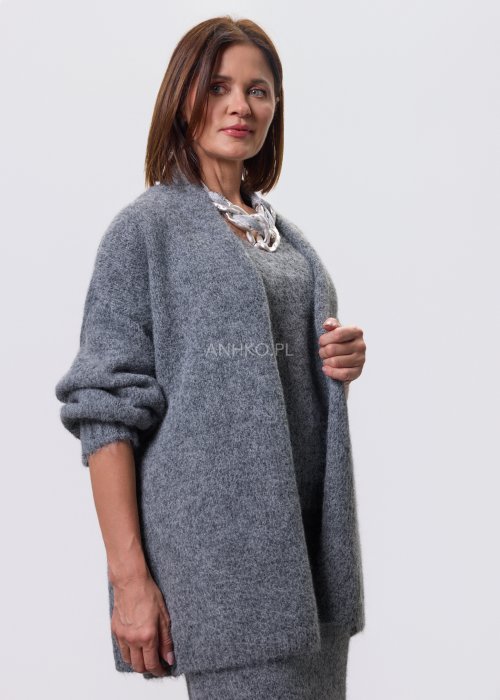 Trzyczęściowy komplet w odcieniu szarości: dzianinowa sukienka midi bez rękawów, długi luźny kardigan oraz dopasowany top, całość uzupełniona masywnym srebrnym naszyjnikiem i czarnymi botkami.