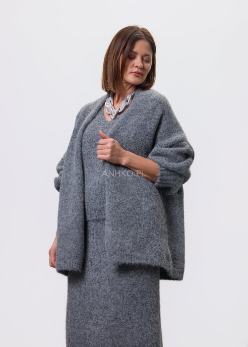 Trzyczęściowy komplet w odcieniu szarości: dzianinowa sukienka midi bez rękawów, długi luźny kardigan oraz dopasowany top, całość uzupełniona masywnym srebrnym naszyjnikiem i czarnymi botkami.