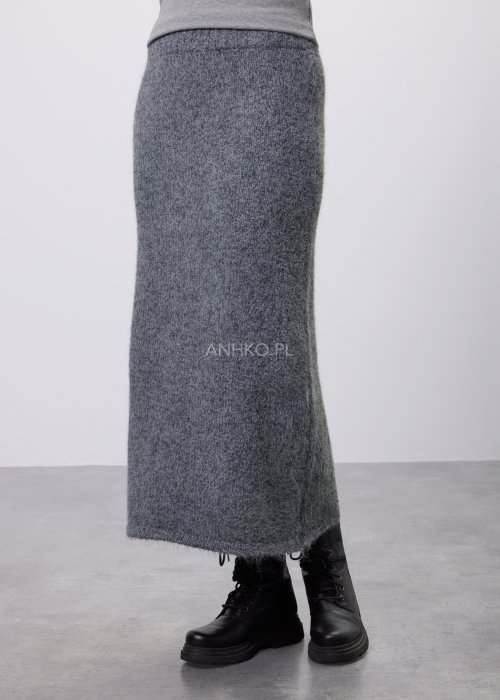 Trzyczęściowy komplet w odcieniu szarości: dzianinowa sukienka midi bez rękawów, długi luźny kardigan oraz dopasowany top, całość uzupełniona masywnym srebrnym naszyjnikiem i czarnymi botkami.