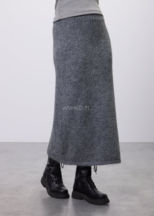 Trzyczęściowy komplet w odcieniu szarości: dzianinowa sukienka midi bez rękawów, długi luźny kardigan oraz dopasowany top, całość uzupełniona masywnym srebrnym naszyjnikiem i czarnymi botkami.