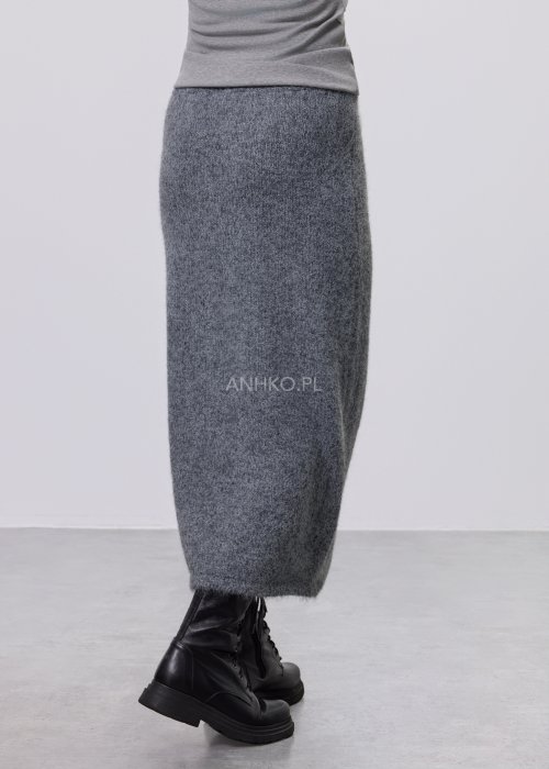 Trzyczęściowy komplet w odcieniu szarości: dzianinowa sukienka midi bez rękawów, długi luźny kardigan oraz dopasowany top, całość uzupełniona masywnym srebrnym naszyjnikiem i czarnymi botkami.