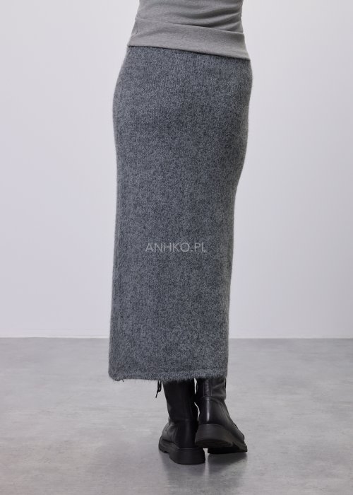 Trzyczęściowy komplet w odcieniu szarości: dzianinowa sukienka midi bez rękawów, długi luźny kardigan oraz dopasowany top, całość uzupełniona masywnym srebrnym naszyjnikiem i czarnymi botkami.