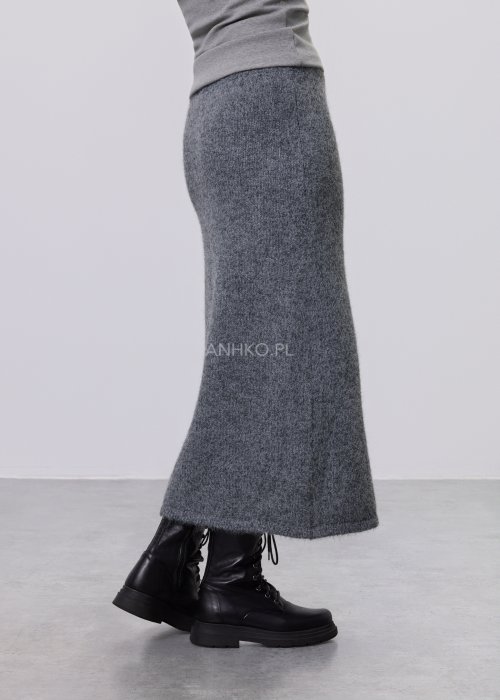 Trzyczęściowy komplet w odcieniu szarości: dzianinowa sukienka midi bez rękawów, długi luźny kardigan oraz dopasowany top, całość uzupełniona masywnym srebrnym naszyjnikiem i czarnymi botkami.