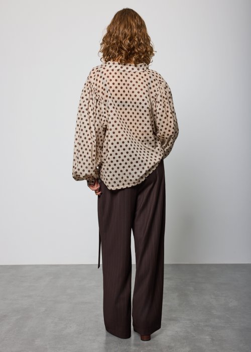 Beżowa, luźna bluzka z lekkiej tkaniny w brązowe grochy, z dekoltem w serek i obszernymi rękawami