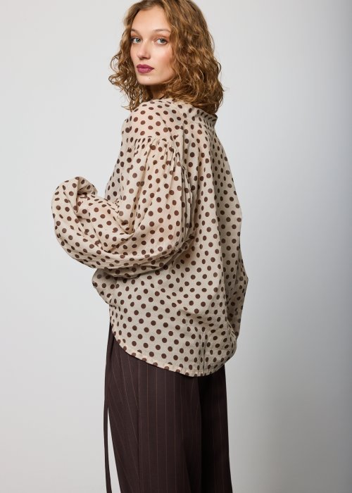 Beżowa, luźna bluzka z lekkiej tkaniny w brązowe grochy, z dekoltem w serek i obszernymi rękawami