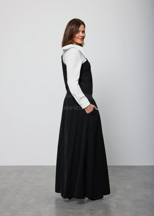 Asymetryczna bluzka damska w kolorze czarnym z dekoltem typu one-shoulder, zestawiona z białą koszulową wstawką pod spodem