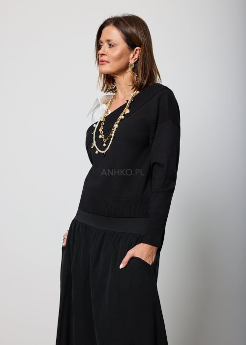 Asymetryczna bluzka damska w kolorze czarnym z dekoltem typu one-shoulder, zestawiona z białą koszulową wstawką pod spodem