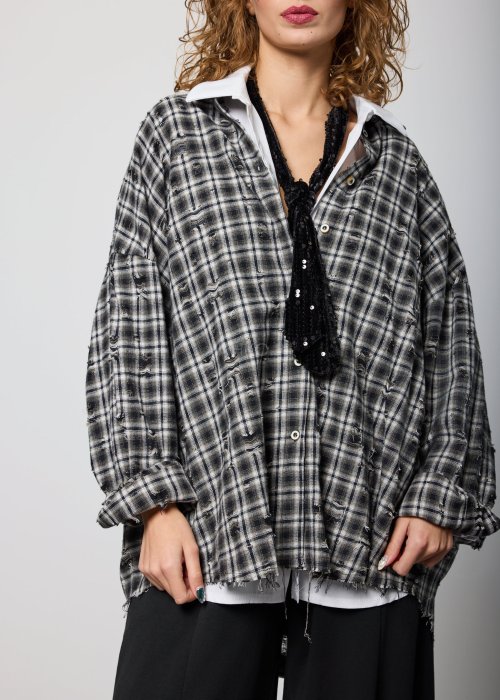 Szara koszula damska oversize w kratę z artystycznymi przetarciami i klasycznym kołnierzykiem. Bawełniany model w stylu grunge prezentowany w miejskiej stylizacji.