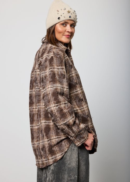 Brązowa koszula damska w kratę oversize z klasycznym kołnierzem i zapięciem na guziki, luźny fason w casualowej stylizacji.