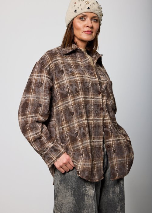 Brązowa koszula damska w kratę oversize z klasycznym kołnierzem i zapięciem na guziki, luźny fason w casualowej stylizacji.