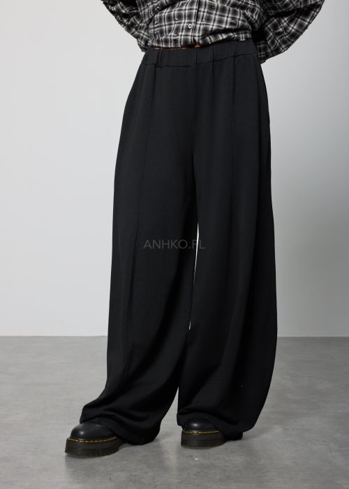 Czarne spodnie damskie o szerokich nogawkach z elastyczną talią, luźny fason w minimalistycznej stylizacji.