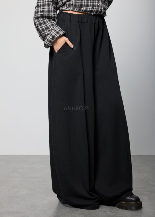 Czarne spodnie damskie o szerokich nogawkach z elastyczną talią, luźny fason w minimalistycznej stylizacji.