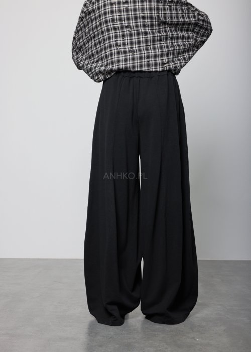 Czarne spodnie damskie o szerokich nogawkach z elastyczną talią, luźny fason w minimalistycznej stylizacji.