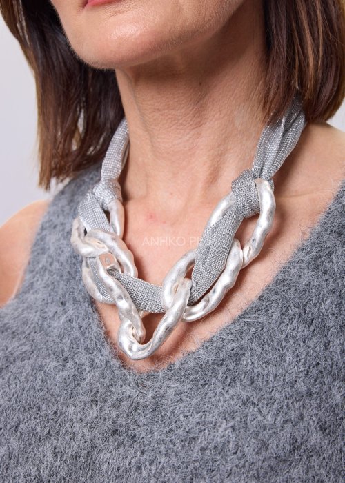 Naszyjnik statement z metalowej siatki i masywnych srebrnych ogniw noszony na szyi, nowoczesna biżuteria damska w industrialnym stylu, elegancka stylizacja