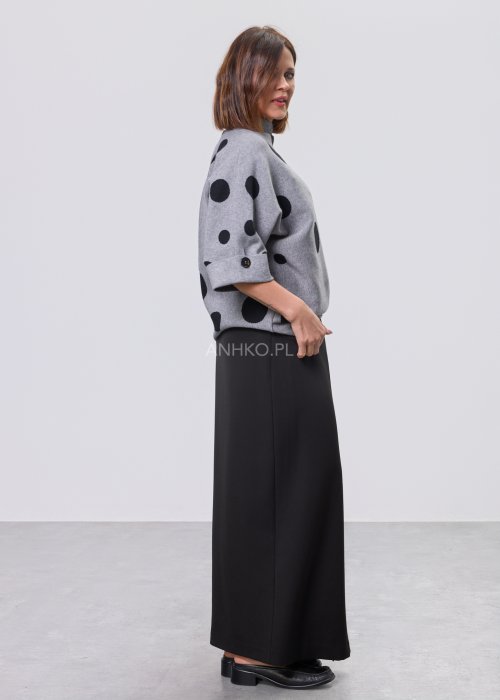 Szara damska bluzka o luźnym kroju z półgolfem, wykonana z miękkiej dzianiny, ozdobiona dużym czarnym wzorem w grochy; rękawy 3/4 z możliwością podpięcia guzikiem