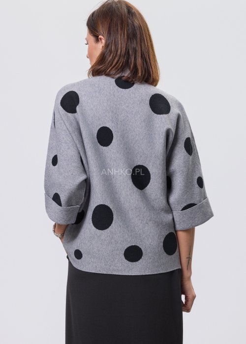 Szara damska bluzka o luźnym kroju z półgolfem, wykonana z miękkiej dzianiny, ozdobiona dużym czarnym wzorem w grochy; rękawy 3/4 z możliwością podpięcia guzikiem