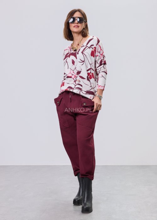 Damska bluzka z dzianiny w kwiatowy wzór w odcieniach bordo, różu i kremu; dekolt w serek, długie rękawy, luźny fason.