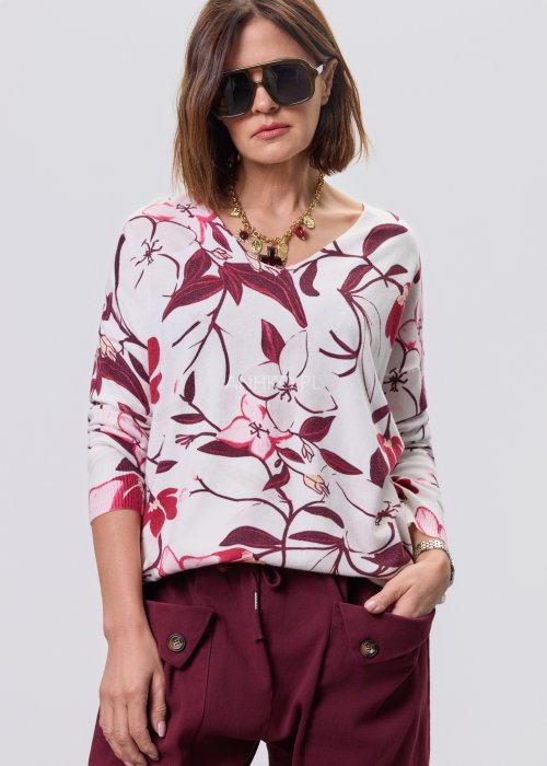 Damska bluzka z dzianiny w kwiatowy wzór w odcieniach bordo, różu i kremu; dekolt w serek, długie rękawy, luźny fason.