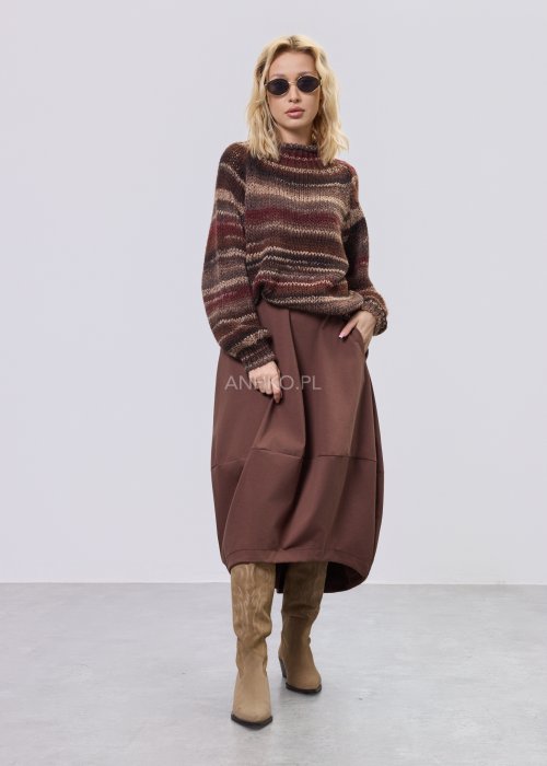 Modelka w brązowej damskiej spódnicy midi o luźnym kroju, z elastycznym czarnym pasem i delikatnymi marszczeniami