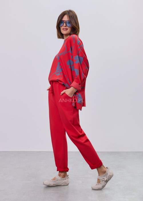 Czerwone spodnie damskie oversize z obniżonym krokiem i elastyczną talią, zestawione z jasną bluzką w casualowej stylizacji.