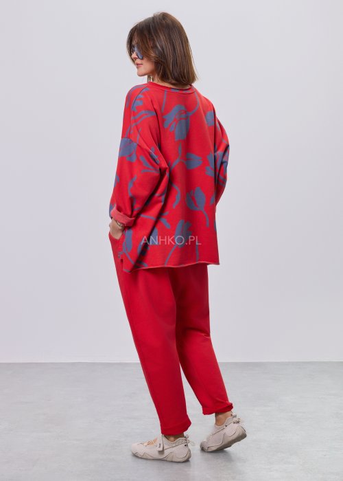 Czerwone spodnie damskie oversize z obniżonym krokiem i elastyczną talią, zestawione z jasną bluzką w casualowej stylizacji.