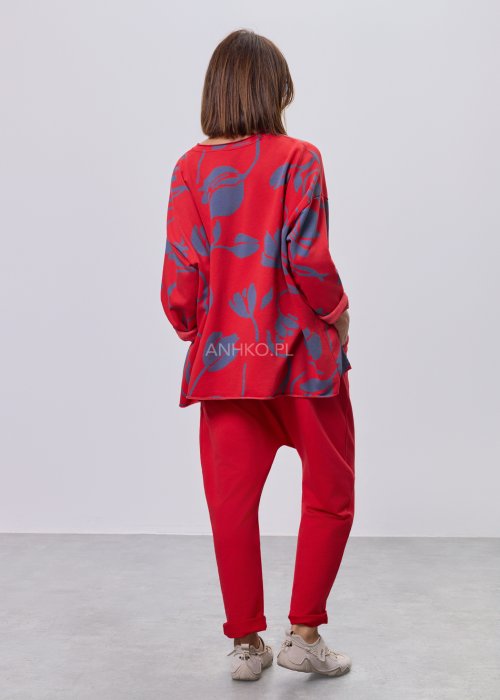 Czerwona damska bluzka o luźnym kroju, z długim rękawem i abstrakcyjnym granatowym nadrukiem, wykonana z miękkiej dzianiny