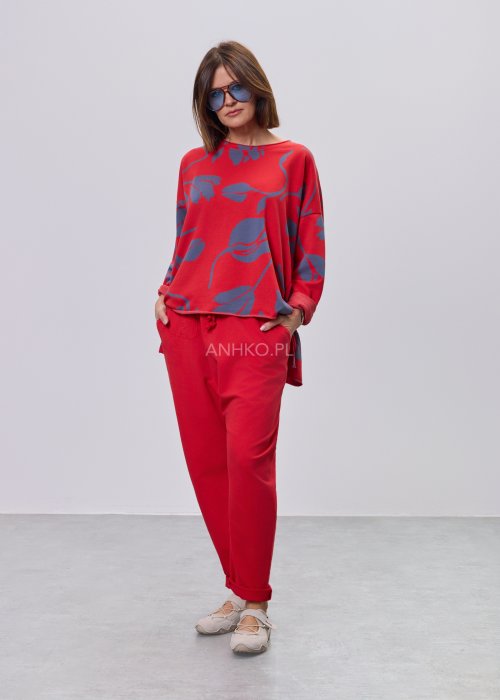 Czerwona damska bluzka o luźnym kroju, z długim rękawem i abstrakcyjnym granatowym nadrukiem, wykonana z miękkiej dzianiny