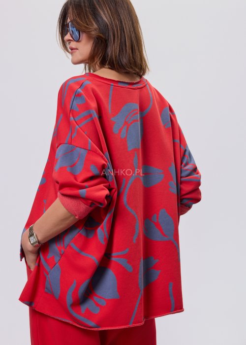 Czerwona damska bluzka o luźnym kroju, z długim rękawem i abstrakcyjnym granatowym nadrukiem, wykonana z miękkiej dzianiny
