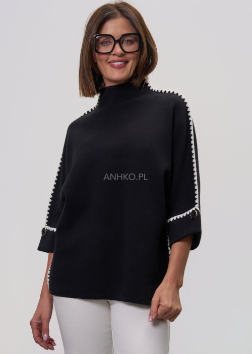 Czarna damska bluzka o luźnym kroju, z półgolfem i rękawami 3/4, ozdobiona kontrastową białą lamówką wzdłuż ramion i rękawów oraz dekoracyjnymi guzikami.