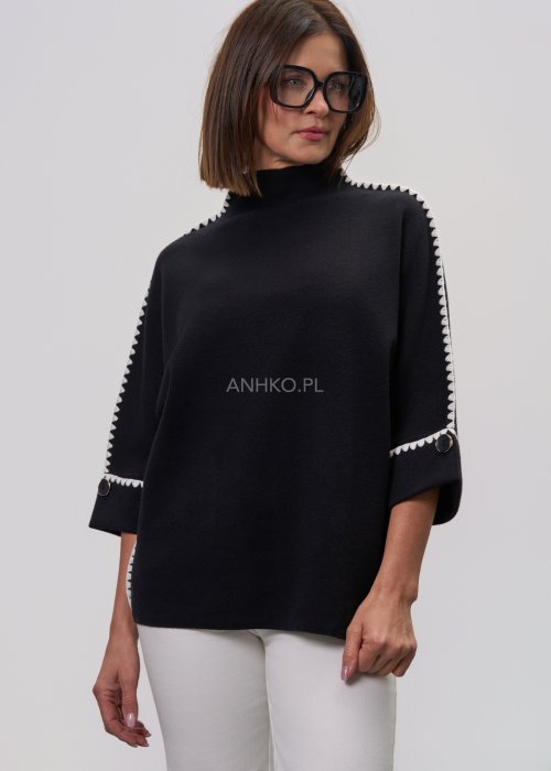Czarna damska bluzka o luźnym kroju, z półgolfem i rękawami 3/4, ozdobiona kontrastową białą lamówką wzdłuż ramion i rękawów oraz dekoracyjnymi guzikami.