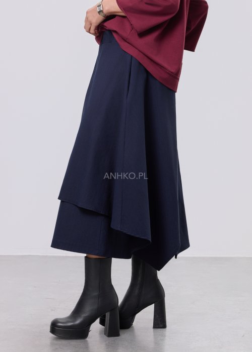 Granatowe damskie spódnico-spodnie o długości midi, z szerokimi, warstwowymi nogawkami imitującymi spódnicę, wykonane z gładkiej tkaniny