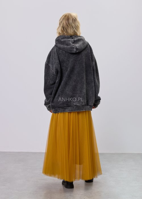 Czarna damska bluza z długim rękawem, ozdobiona kolorowym nadrukiem graficznym na przodzie, o luźnym kroju, zestawiona z żółto-czarną spódnicą we wzór.