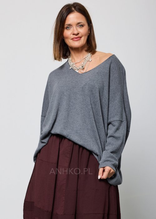 Luźny, szary sweter z długim rękawem i dekoltem w serek, noszony do burgundowej spódnicy