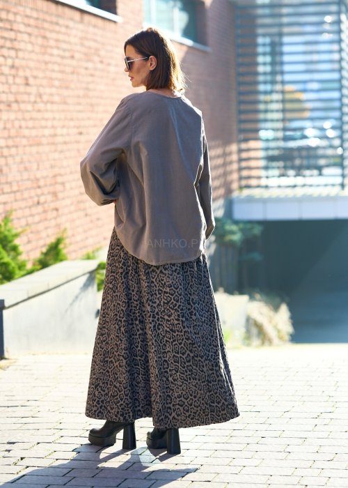 Stylowa kobieta w beżowej bluzce z aplikacją kwiatową i długiej spódnicy w panterkowy wzór