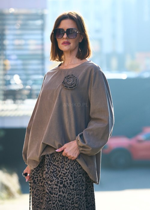 Stylowa kobieta w beżowej bluzce z aplikacją kwiatową i długiej spódnicy w panterkowy wzór