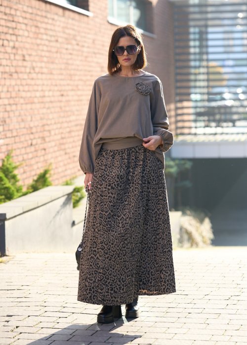 Stylowa kobieta w beżowej bluzce z aplikacją kwiatową i długiej spódnicy w panterkowy wzór