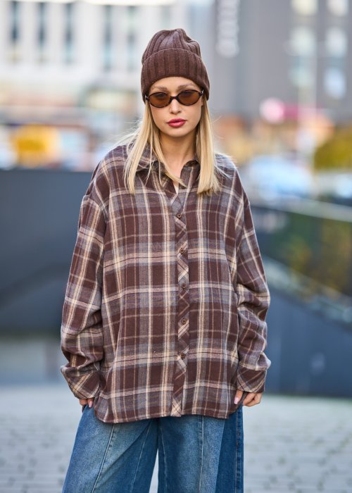 Koszula oversize w brązowo-beżową kratę z długim rękawem i guzikami, stylizacja z jeansami i czapką.