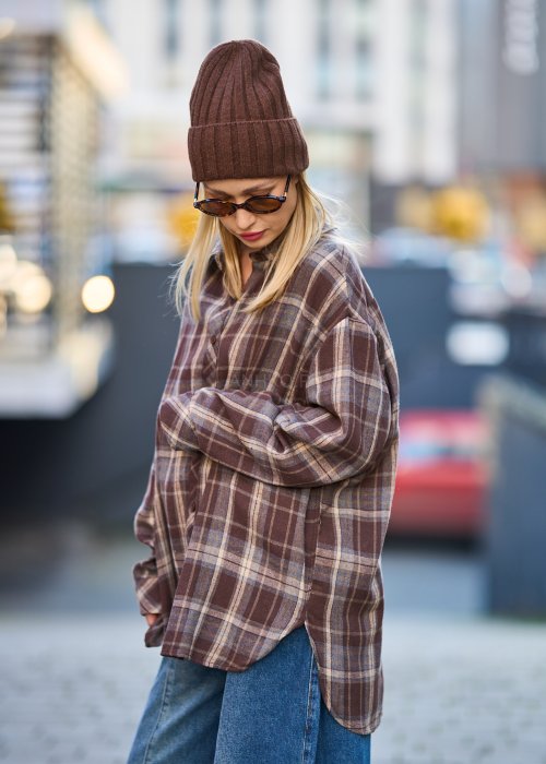 Koszula oversize w brązowo-beżową kratę z długim rękawem i guzikami, stylizacja z jeansami i czapką.