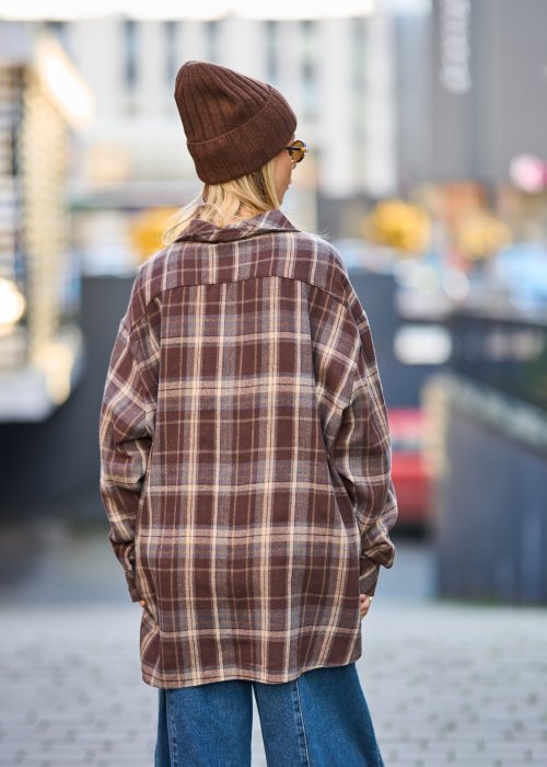 Koszula oversize w brązowo-beżową kratę z długim rękawem i guzikami, stylizacja z jeansami i czapką.