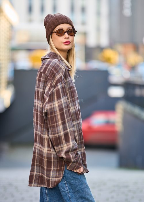 Koszula oversize w brązowo-beżową kratę z długim rękawem i guzikami, stylizacja z jeansami i czapką.