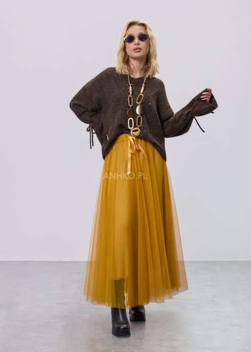 Brązowy sweter damski o luźnym kroju z ozdobnym wiązaniem na rękawach, zestawiony z musztardową spódnicą w stylu casual