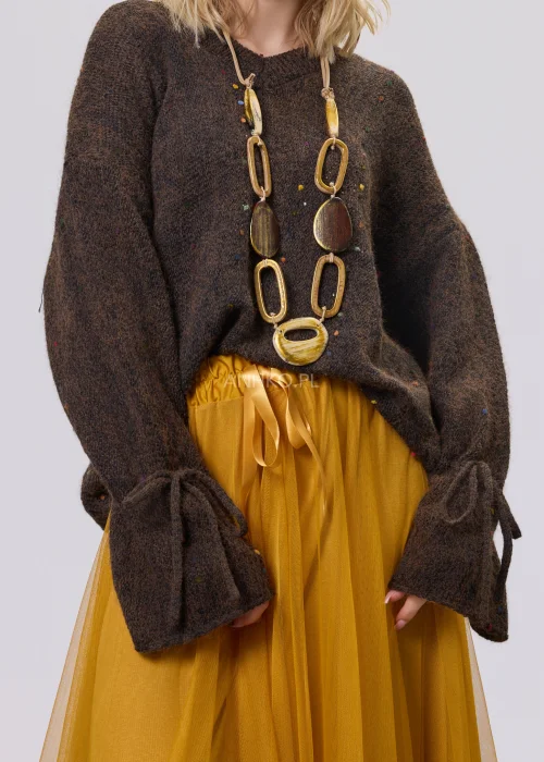 Sweter damski oversize z miękkiej, lekko puszystej dzianiny w kolorze ciemnego czekoladowego brązu, ozdobiony drobnymi, wielokolorowymi akcentami przypominającymi konfetti, z dekoltem w serek, obniżoną linią ramion