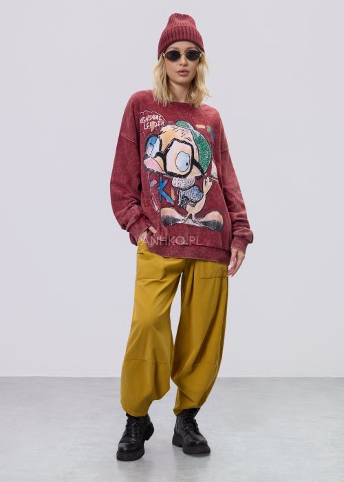 Bordowa bluza damska z efektem sprania i dużym, artystycznym nadrukiem, zestawiona z musztardowymi spodniami w stylu streetwear