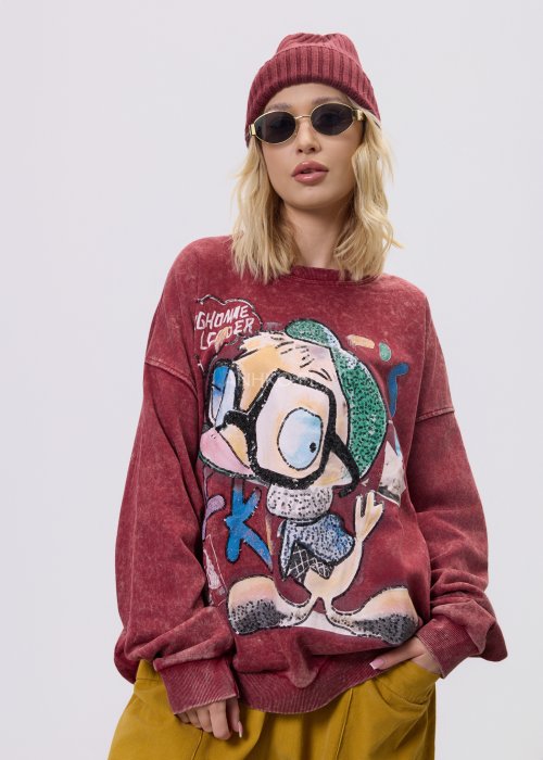 Bordowa bluza damska z efektem sprania i dużym, artystycznym nadrukiem, zestawiona z musztardowymi spodniami w stylu streetwear