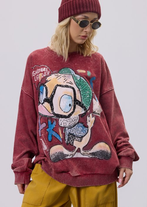 Bordowa bluza damska z efektem sprania i dużym, artystycznym nadrukiem, zestawiona z musztardowymi spodniami w stylu streetwear